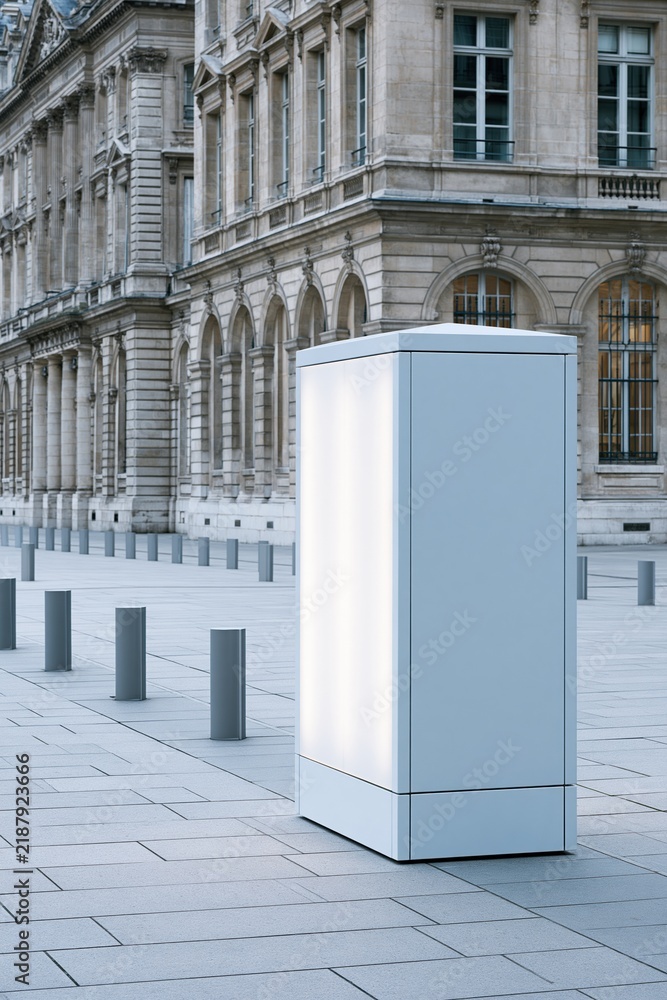 Obraz premium Modern illuminated advertising kiosk stands before classical stone