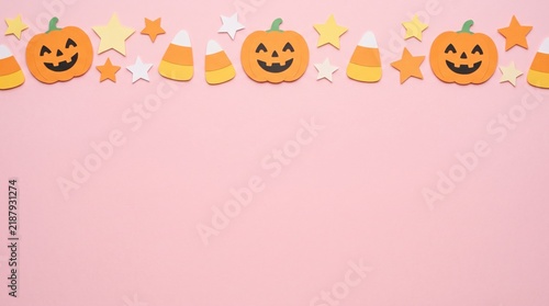 A festive Halloween border featuring smiling jack-o'-lanterns, candy corn, and colorful stars on a pastel pink background.