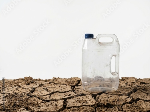 Empty Plastic Water Container on Dry Cracked Earth