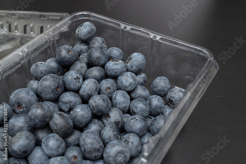 Fotografie Blueberries inside an open transparent plastic container high angle view