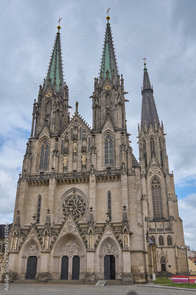 Fototapeta premium Front facade of the neo-Gothic Saint Wenceslaus Cathedral with high spires under a cloudy day sky in Olomouc, Czech Republic.