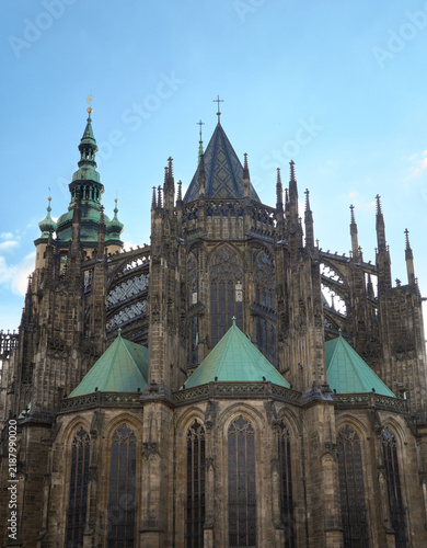 Detailed view of the Gothic apse, flying buttresses, and copper spires of St. Vitus Cathedral in Prague Castle, Czech Republic.