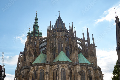 Detailed view of the Gothic apse, flying buttresses, and copper spires of St. Vitus Cathedral in Prague Castle, Czech Republic.