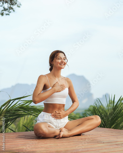 Happy Woman Meditating in Nature With Hands on Heart and Stomach