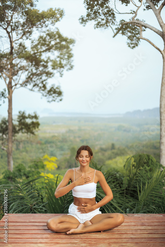Calm Woman Doing Pranayama Meditation Outdoors On Terrace With Nature