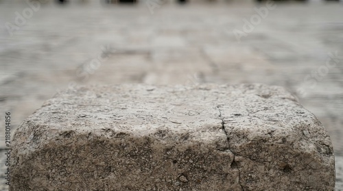 Stone block podium on cobblestone ground