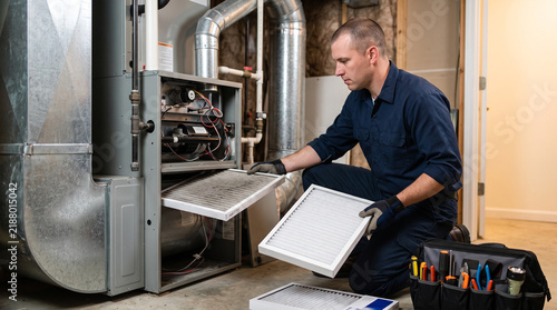 HVAC technician replacing furnace air filter during maintenance