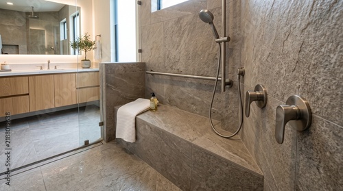 Modern Accessible home bathroom with a walk-in stone shower bench, grab bars, and contemporary vanity
