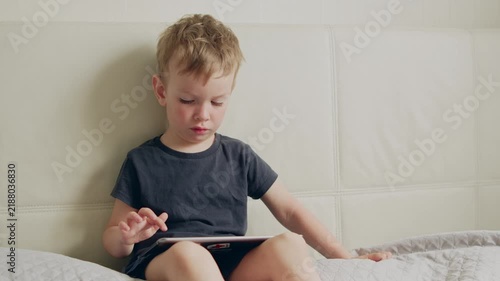 Portrait of a baby using a device for online learning or entertainment.