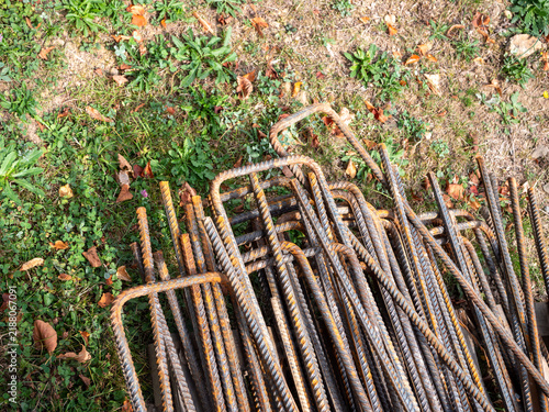 Obraz na płótnie Close-up of rusty bent steel rebar with ribbed surface, showing reinforcing material for concrete construction, structural engineering, metal fabrication and corrosion