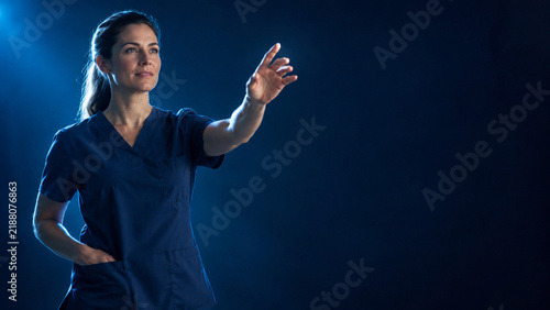 Clinician in scrubs reaching forward with one hand while the other res