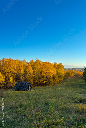 Golden autumn colors light up the countryside among old wooden houses and ancient churches in Ukraine, creating a warm nostalgic atmosphere.