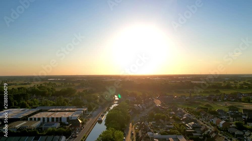 Golden Hour Aerial Flight Over a Picturesque European Town and Canal Towards a Brilliant Sunset