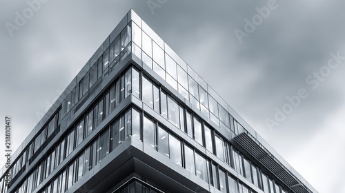 Modern glass building presents sleek architecture under dramatic stormy clouds, concept for urban development and corporate design