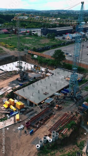 Aerial drone footage of a large residential construction project with unfinished apartment buildings, concrete structures and surrounding urban infrastructure.
