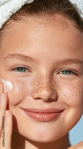 Smiling girl resting her cheek on her hand in a close portrait, happy childhood, confidence, cheerful expression, wellbeing.