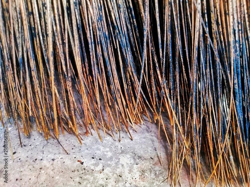 This photo shows a traditional twig broom made from a bundle of dried palm ribs tied together.