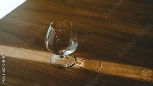 Empty brandy snifter glass on a wooden table