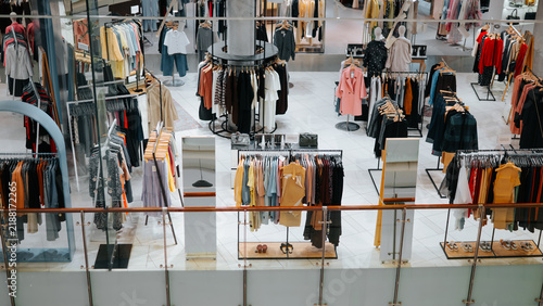 Картината върху платно A clothing store features multiple displays of various apparel for sale