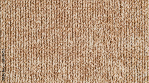 Knit fabric texture showing a warm beige wool or cotton pattern for fashion, textile design, and cozy apparel concepts creating comfort background