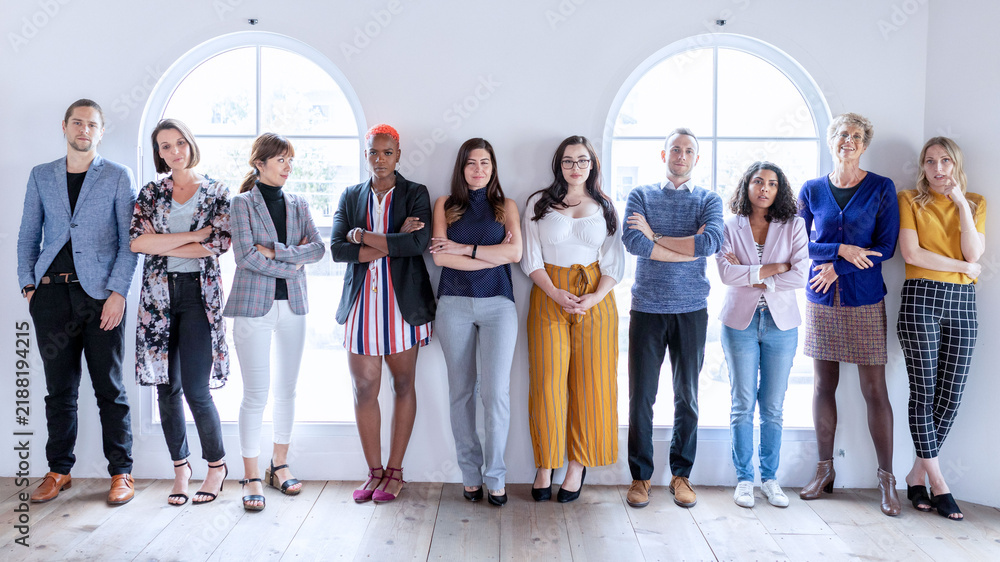 Fototapeta premium Diverse group of men and women standing together in a bright studio