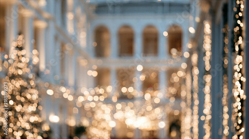 Blurred soft focus grand interior with glowing holiday light, decorated tree, elegant arch, warm illumination, and festive atmosphere creating luxurious seasonal scene