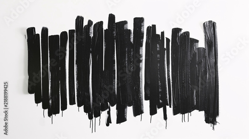Black paint brush strokes on a white background with texture