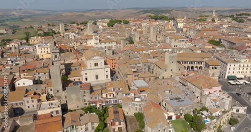 Aerial view of the historic center of Tarquinia, in the province of Viterbo, in Lazio, Central Italy, with many medieval towers, the tiled rooftops of the houses and the hills of the countryside.
