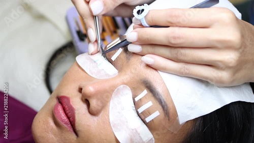 The process of eyelash extension and volume increase in a professional beauty salon, close-up view