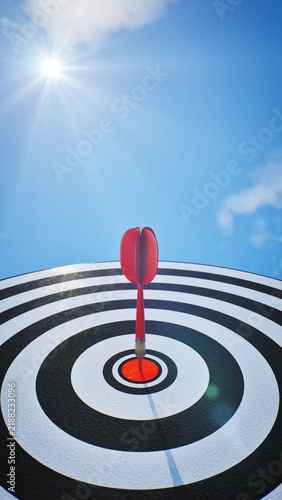 Bild auf Leinwand Strategic leadership and vision, low angle perspective of red dart arrow on center bullseye under bright sun