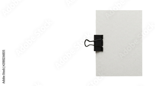 Cuadro en lienzo Blank white paper document held together by a sturdy black metal binder clip iso