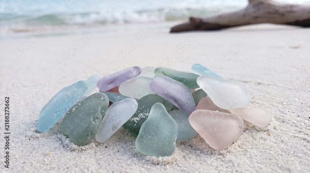 Fototapeta premium Multi-colored pastel sea glass pieces on a white sand tropical beach