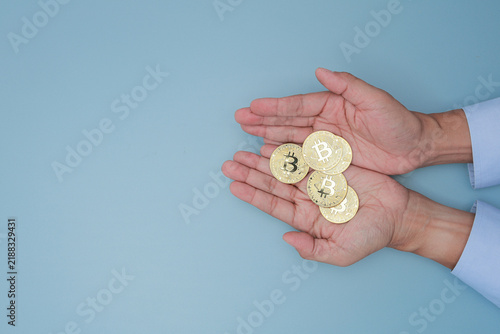 Businessman hand holding golden coin showing crypto asset management with confident hope for modern financial wealth and security