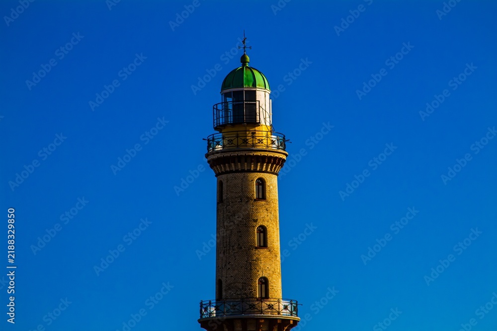 Obraz premium Historic lighthouse against a clear blue sky