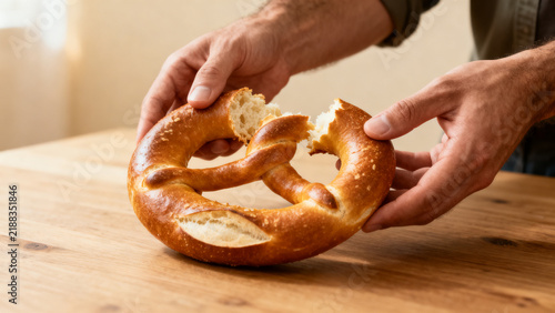 Obraz na płótnie Hand holding soft pretzel against soft background