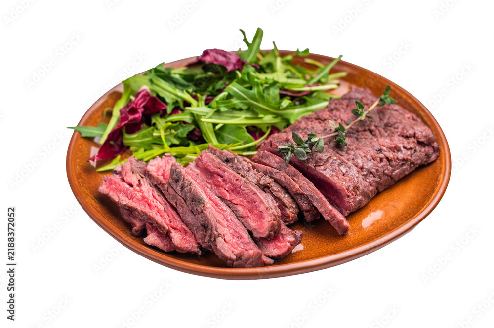 Fototapeta premium Grilled Skirt machete beef steak, roasted sliced meat on plate with salad isolated on white background. top view