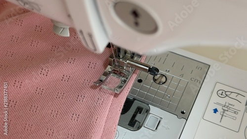 Obraz na płótnie Close-up view of a sewing machine presser foot stitching fabric during the sewing process