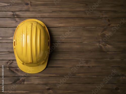 Yellow construction helmet placed on wooden surface in industrial setting