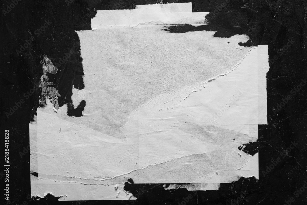 Obraz premium An old torn poster without inscriptions, close-up on a black background