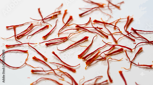 Close up view of red saffron threads scattered on a white background