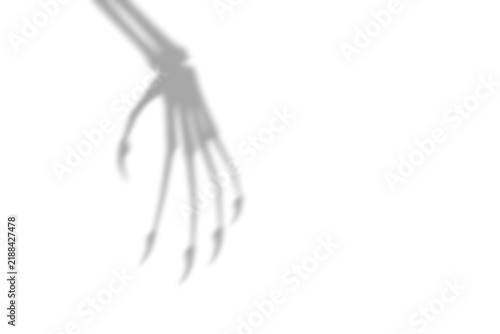 Foto A dark spooky shadow of a skeletal hand with long sharp fingers cast on a surfac