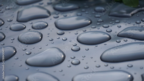 Bild auf Leinwand Water droplets on smooth gray surface forming abstract pattern, highlighting purity, freshness, surface tension and clean minimal background for hygiene, technology or design concepts