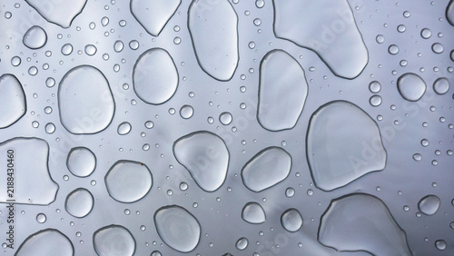 Konstfotografi Water droplets on smooth gray surface forming abstract pattern, highlighting purity, freshness, surface tension and clean minimal background for hygiene, technology or design concepts