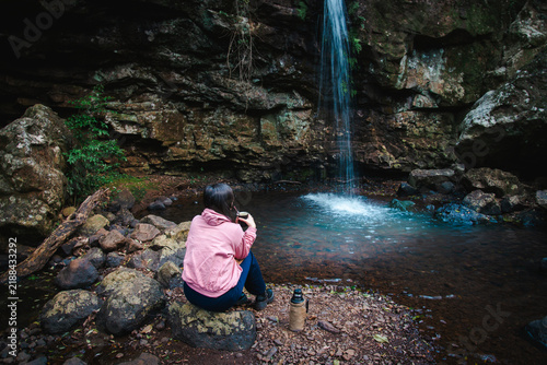 Foto Mujer disfrutando de una cascada en un entorno natural