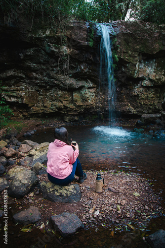 Obraz na płótnie Mujer disfrutando de una cascada en un entorno natural