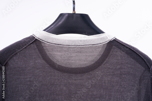 Foto A semi-sheer knit top hanging on a hanger, showcasing the neckline details
