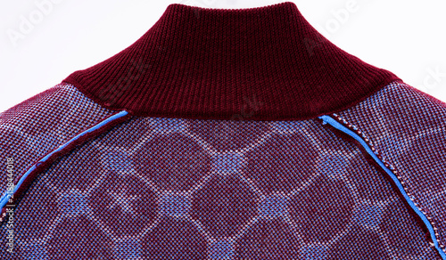 Принти на полотні A semi-sheer knit top hanging on a hanger, showcasing the neckline details