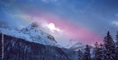 Full moon and abstract stars sky in a winter mountains.