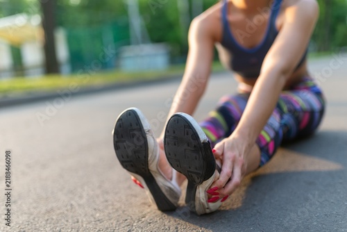 Close up of a fit woman stretching her legs on the ground