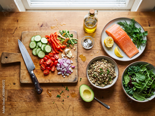 Fresh ingredients ready for cooking a healthy salmon and quinoa meal with avocado and fresh greens
